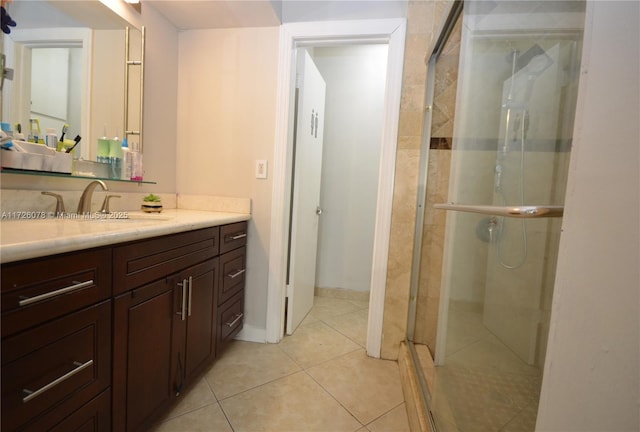 bathroom featuring a shower with shower door, tile patterned floors, and vanity