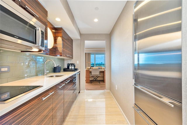 kitchen with appliances with stainless steel finishes, decorative backsplash, and sink