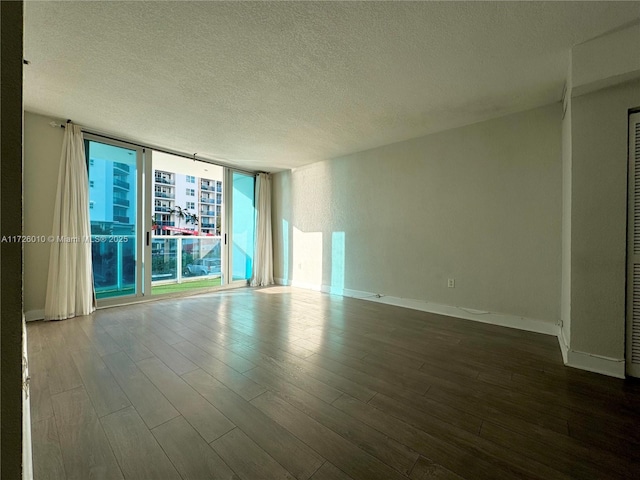 spare room with a textured ceiling, hardwood / wood-style floors, and expansive windows