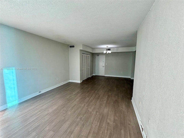 empty room featuring a textured ceiling and wood-type flooring