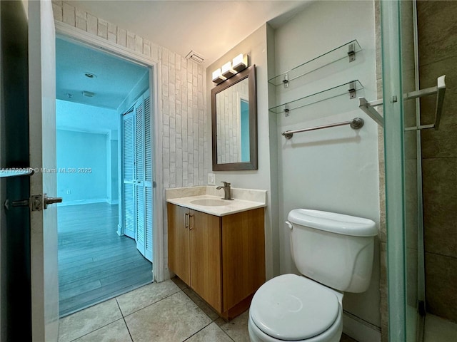 bathroom with toilet, vanity, and tile patterned floors