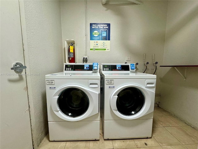 laundry area with washing machine and dryer and light tile patterned floors