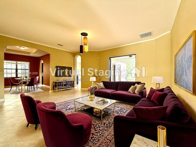 tiled living area featuring visible vents, arched walkways, baseboards, and crown molding