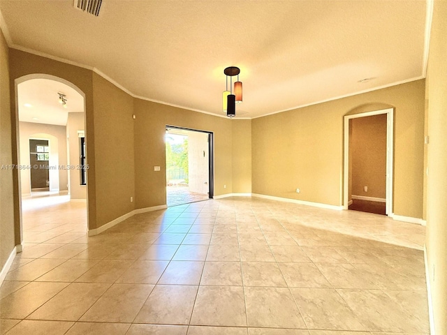 empty room featuring visible vents, arched walkways, ornamental molding, and light tile patterned flooring