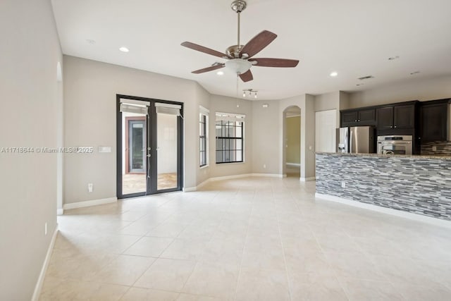 unfurnished living room featuring arched walkways, recessed lighting, french doors, and ceiling fan