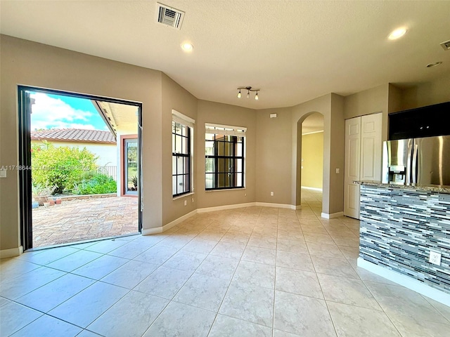 interior space with arched walkways, visible vents, and baseboards