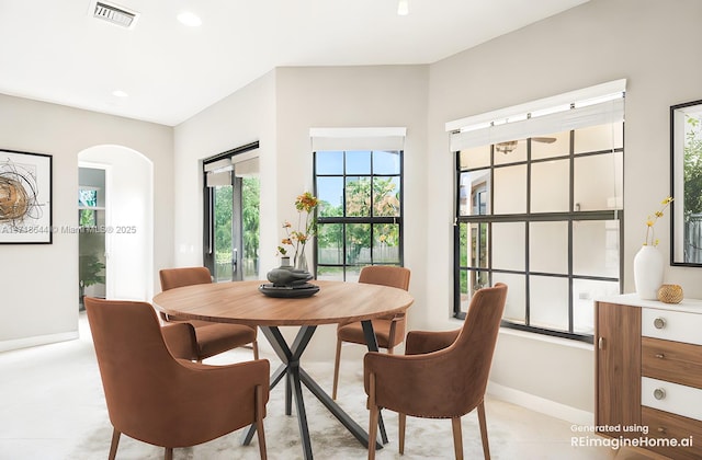 dining space with arched walkways, visible vents, baseboards, and recessed lighting