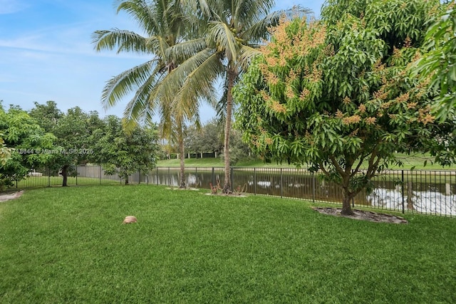 view of yard with a water view and fence