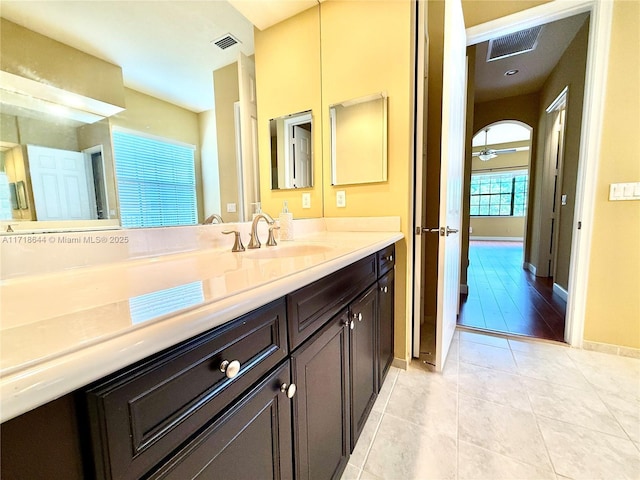 bathroom featuring baseboards, visible vents, tile patterned flooring, and vanity