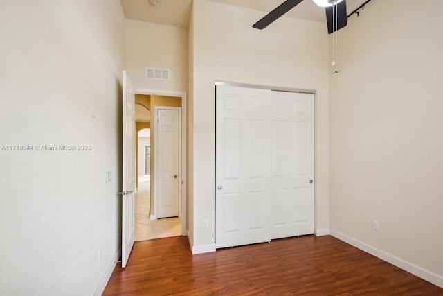 8771 NW 41st St, Cooper City, FL 33024 - unfurnished bedroom with wood finished floors, baseboards, a closet, a ceiling fan, and a towering ceiling