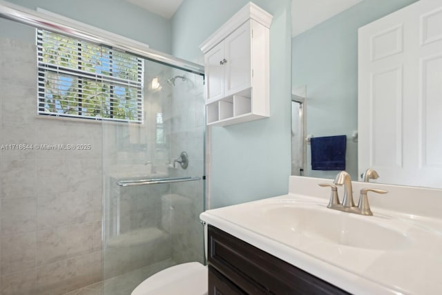 bathroom featuring toilet, a stall shower, and vanity