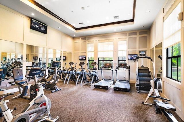 gym featuring visible vents, a towering ceiling, recessed lighting, and crown molding