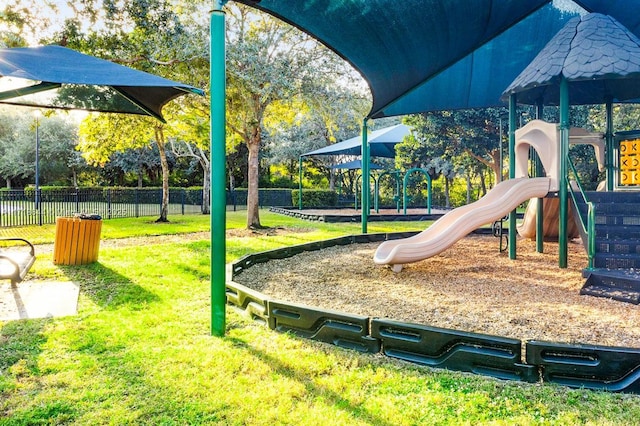 community play area with a yard and fence