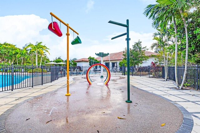 view of property's community featuring a swimming pool and fence