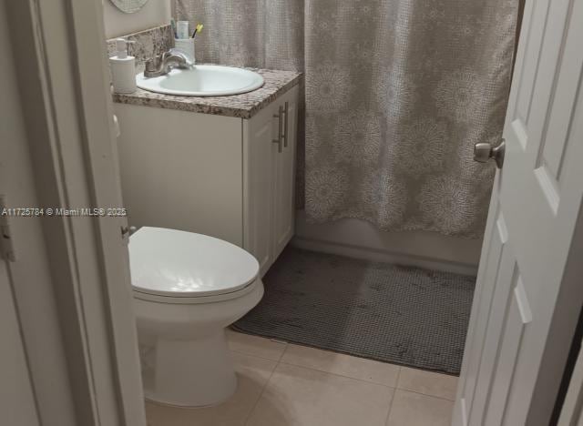 bathroom featuring vanity, tile patterned floors, and toilet