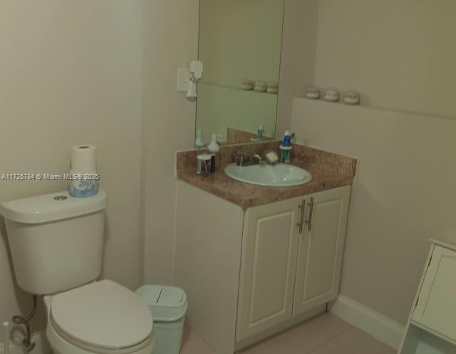 bathroom with toilet, vanity, and tile patterned floors