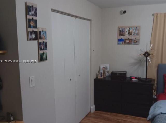 bedroom with wood-type flooring and a closet