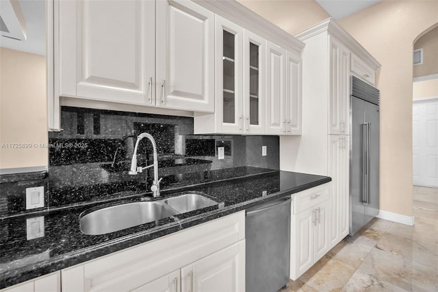 kitchen featuring white cabinetry, appliances with stainless steel finishes, sink, and dark stone countertops