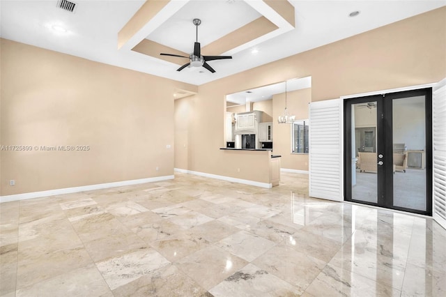 unfurnished living room featuring ceiling fan with notable chandelier and french doors