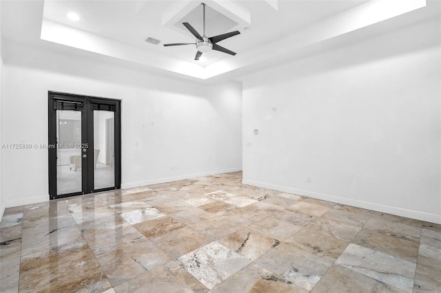 spare room featuring a raised ceiling and ceiling fan