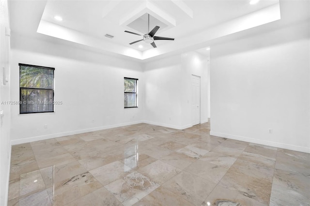 empty room featuring ceiling fan, a tray ceiling, and coffered ceiling