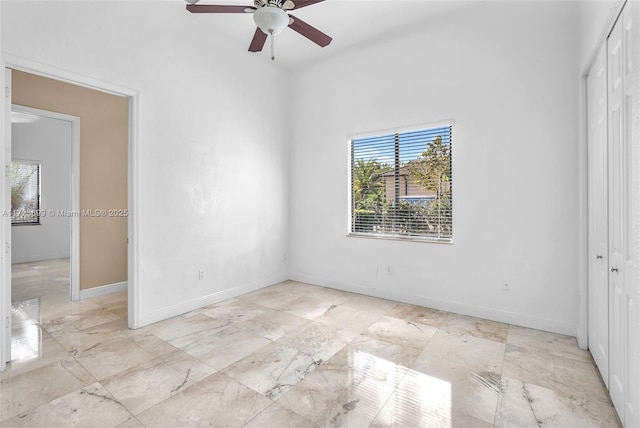 unfurnished bedroom with ceiling fan and a closet