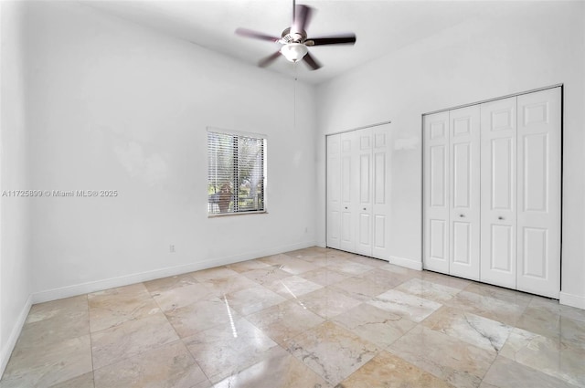 unfurnished bedroom with multiple closets and ceiling fan