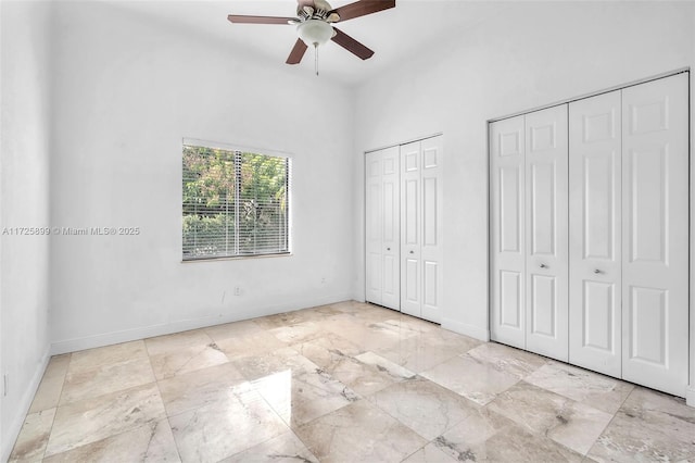 unfurnished bedroom featuring two closets and ceiling fan