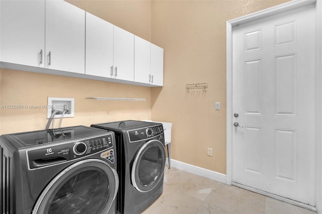 washroom with cabinets and washer and dryer