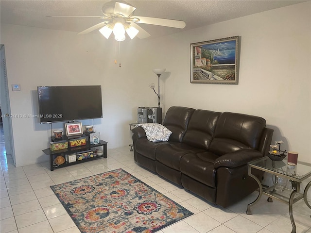 living room featuring a textured ceiling, ceiling fan, and light tile patterned floors