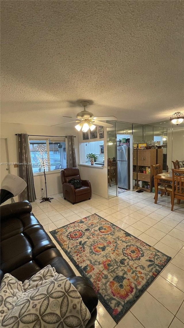 tiled living room featuring ceiling fan and a textured ceiling