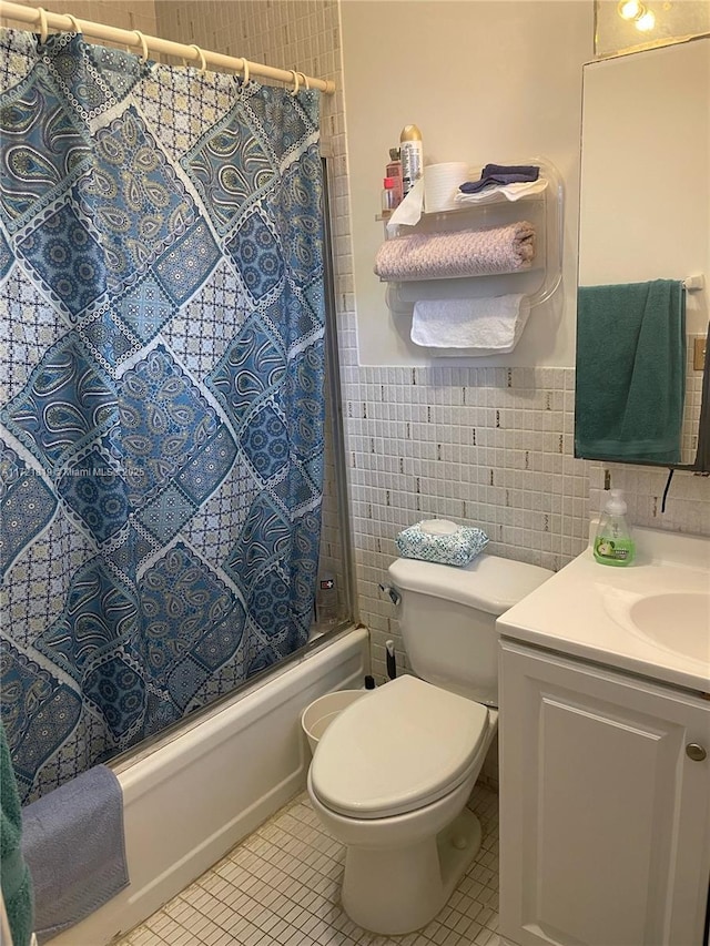 full bathroom featuring toilet, tile patterned flooring, tile walls, and shower / bathtub combination with curtain