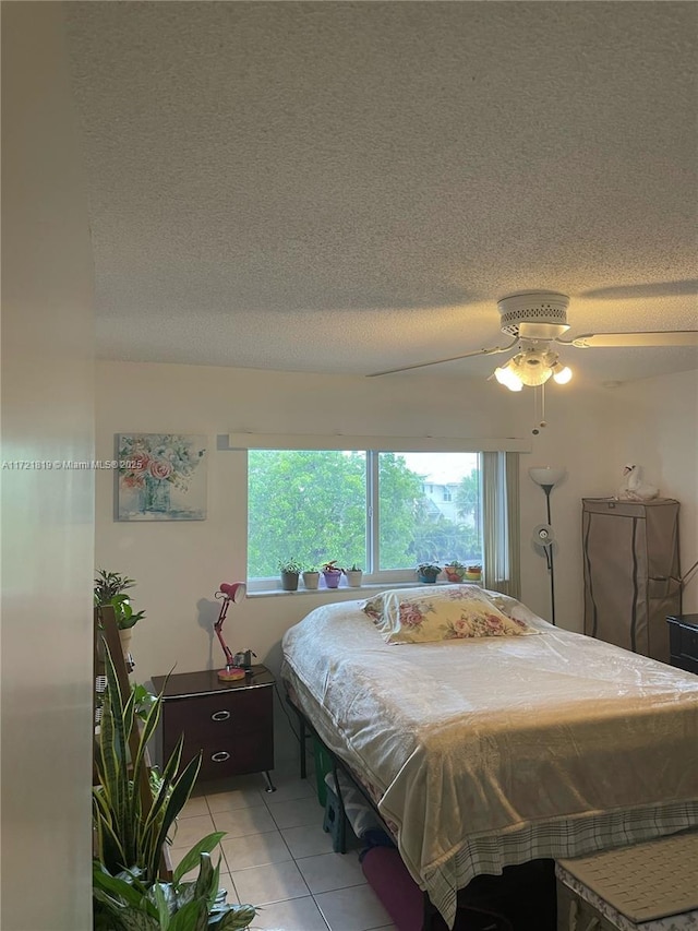 tiled bedroom featuring a textured ceiling and ceiling fan