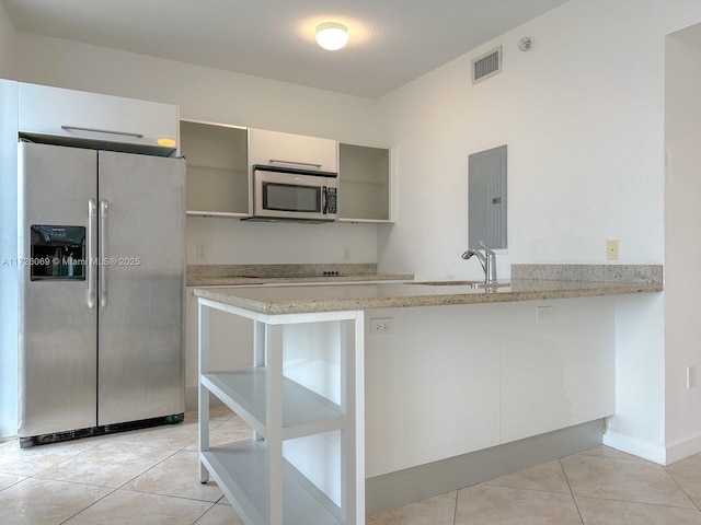 kitchen with kitchen peninsula, electric panel, appliances with stainless steel finishes, light tile patterned flooring, and sink