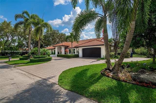 mediterranean / spanish-style house featuring a garage and a front lawn