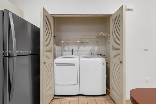 laundry area with light tile patterned flooring and washing machine and clothes dryer