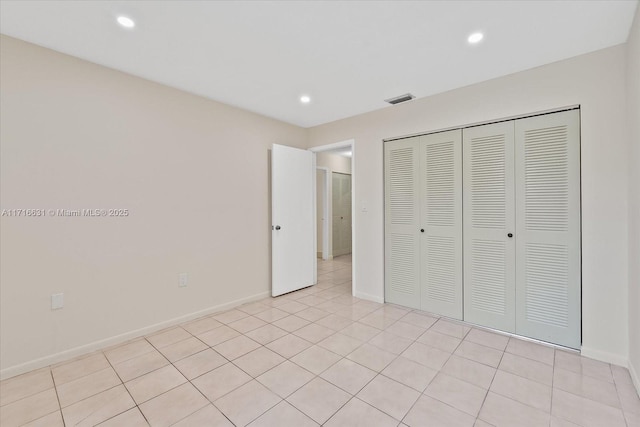 unfurnished bedroom with light tile patterned flooring and a closet