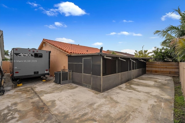 rear view of property with central AC, a sunroom, and a patio