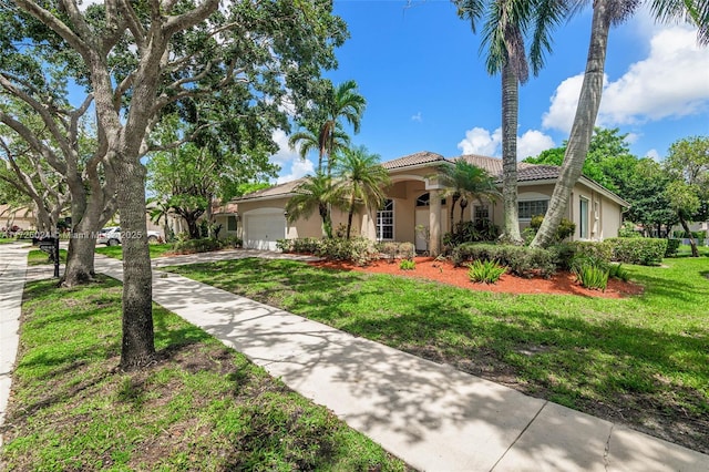 mediterranean / spanish-style home with a front lawn and a garage