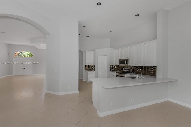 kitchen featuring backsplash, sink, white cabinetry, appliances with stainless steel finishes, and light tile patterned floors