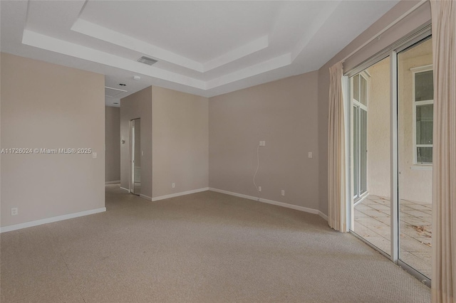 unfurnished room featuring a tray ceiling