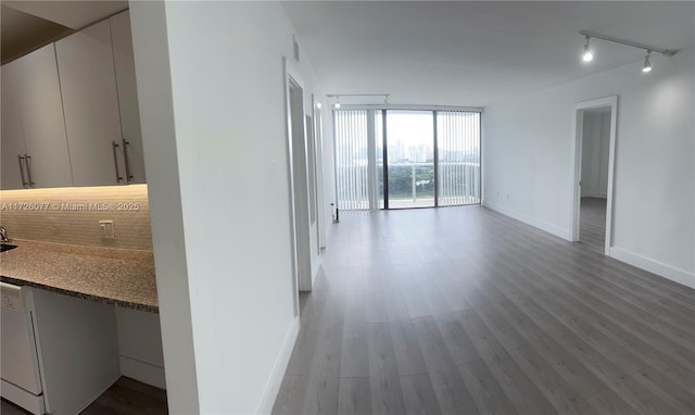 hallway with a wall of windows and wood-type flooring