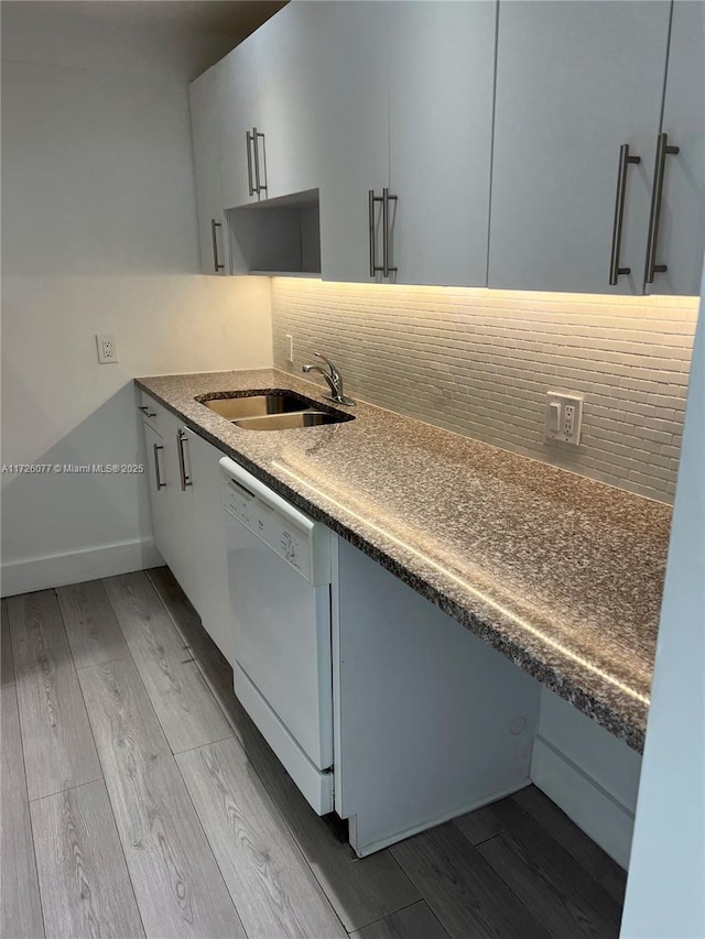 kitchen featuring light hardwood / wood-style floors, sink, dishwasher, and tasteful backsplash