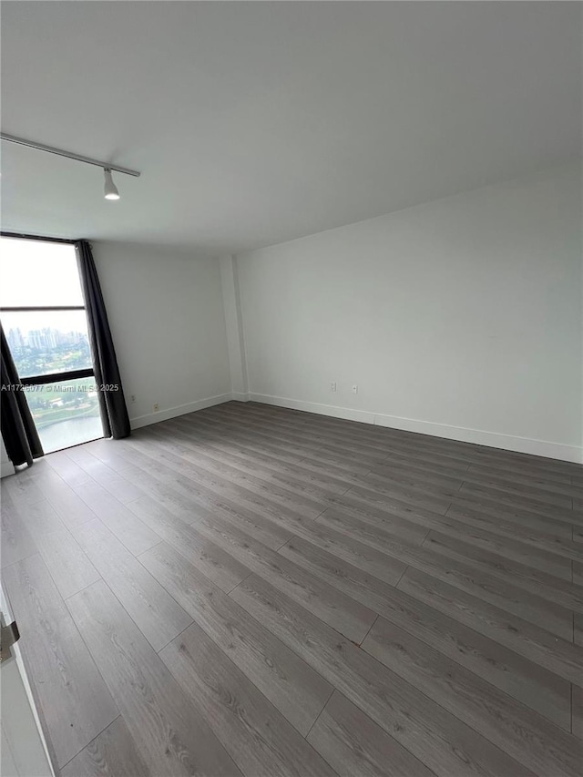 spare room featuring track lighting and hardwood / wood-style floors