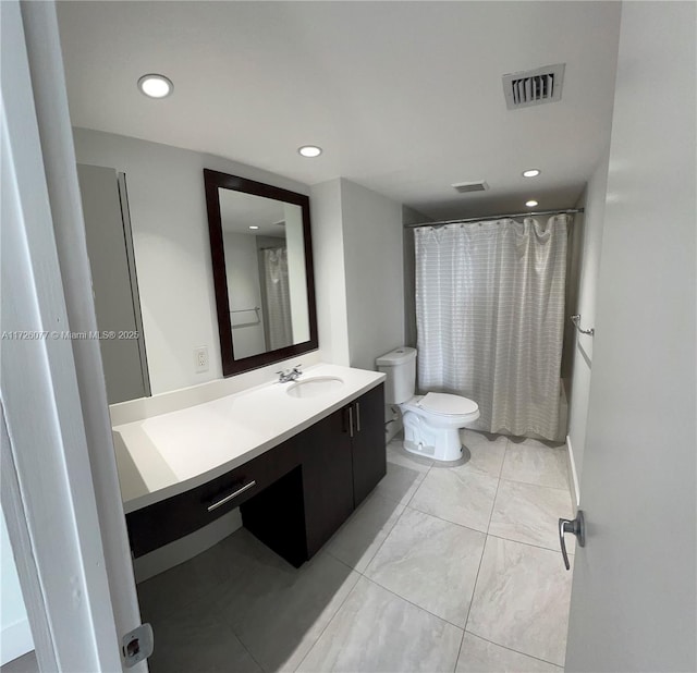 bathroom featuring toilet, vanity, and curtained shower