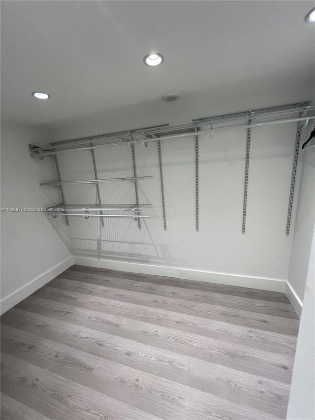 spacious closet with light hardwood / wood-style flooring