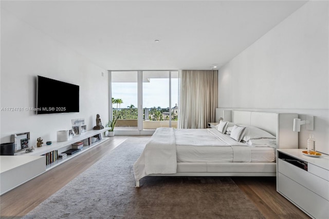 bedroom featuring a wall of windows, dark hardwood / wood-style flooring, and access to outside