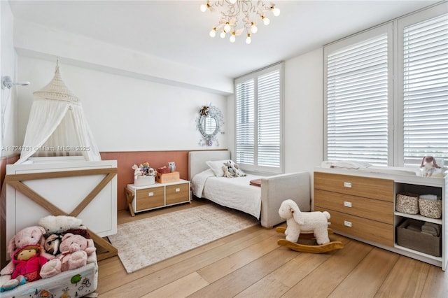 bedroom with hardwood / wood-style floors and an inviting chandelier