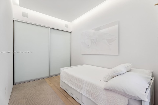 bedroom with a closet and light hardwood / wood-style flooring