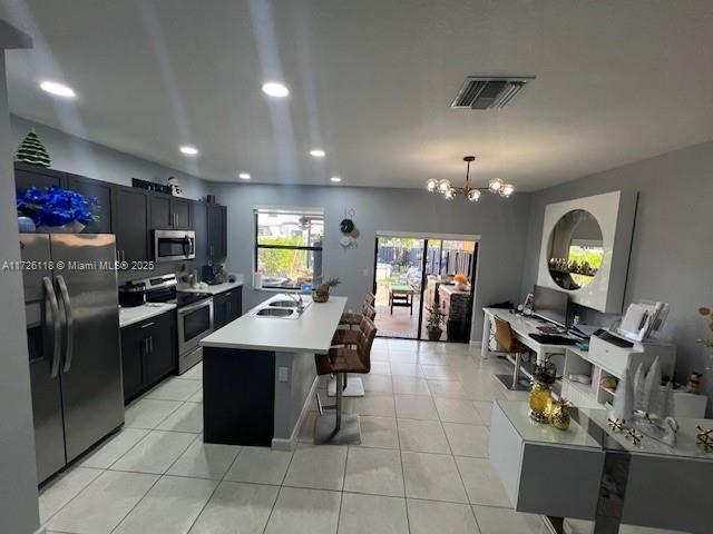 kitchen featuring appliances with stainless steel finishes, light tile patterned floors, a chandelier, and hanging light fixtures